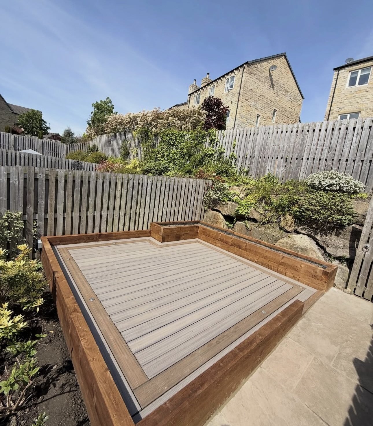 Completed raised composite deck with timber edging